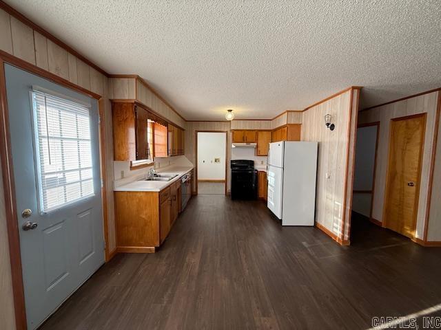 kitchen with dark hardwood / wood-style flooring, white refrigerator, range, crown molding, and a textured ceiling