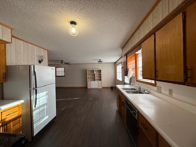 kitchen with dark hardwood / wood-style floors, refrigerator, dishwasher, sink, and crown molding