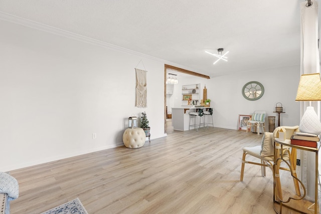 sitting room featuring crown molding, a textured ceiling, and light wood-type flooring