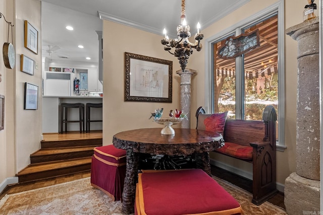 dining room with crown molding, a chandelier, and hardwood / wood-style flooring