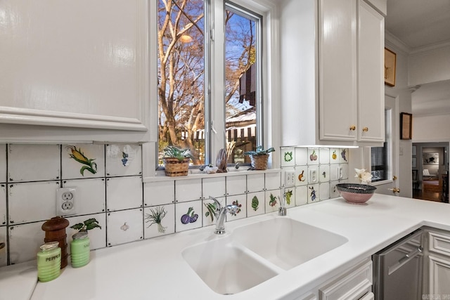 kitchen with dishwashing machine, sink, white cabinets, and decorative backsplash