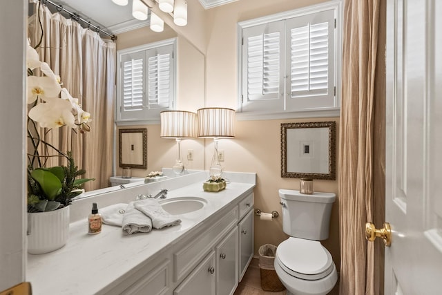 bathroom with crown molding, plenty of natural light, vanity, and toilet