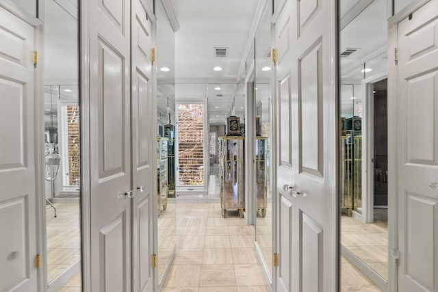 corridor featuring crown molding and light tile patterned floors