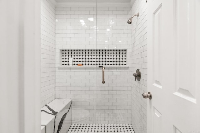 bathroom with crown molding and tiled shower