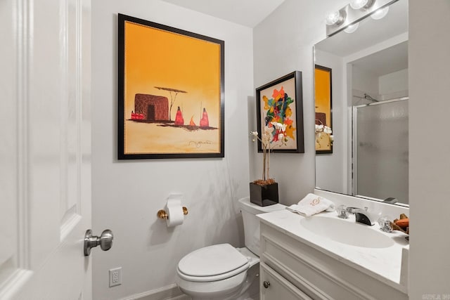 bathroom with an enclosed shower, vanity, and toilet