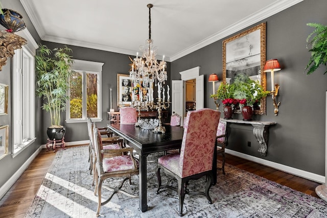 dining space with hardwood / wood-style flooring, crown molding, and a chandelier