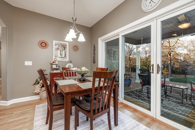 dining room featuring french doors, an inviting chandelier, and light hardwood / wood-style flooring