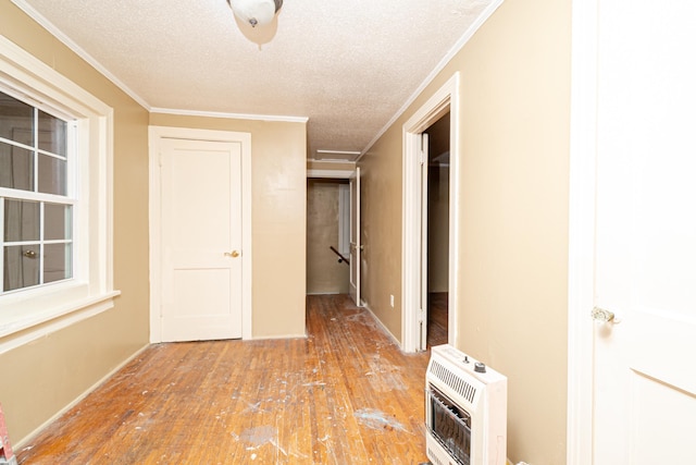 hallway with hardwood / wood-style floors, crown molding, heating unit, and a textured ceiling