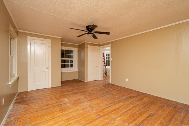 unfurnished room with crown molding, ceiling fan, hardwood / wood-style flooring, and a textured ceiling