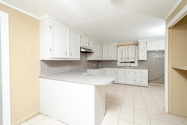 kitchen with sink, white cabinetry, tasteful backsplash, light tile patterned floors, and kitchen peninsula