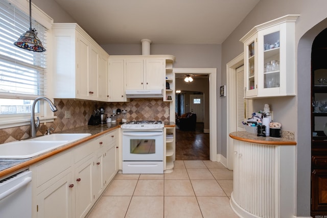 kitchen featuring sink, white appliances, light tile patterned floors, white cabinetry, and tasteful backsplash