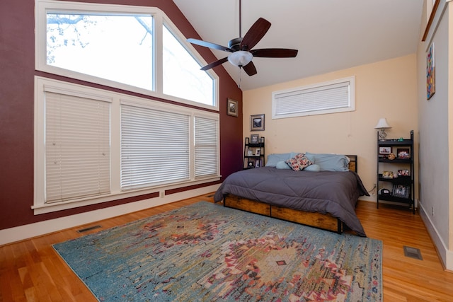 bedroom featuring ceiling fan, high vaulted ceiling, hardwood / wood-style floors, and multiple windows