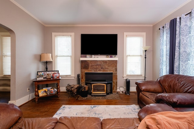 living room with hardwood / wood-style flooring, crown molding, and a wood stove