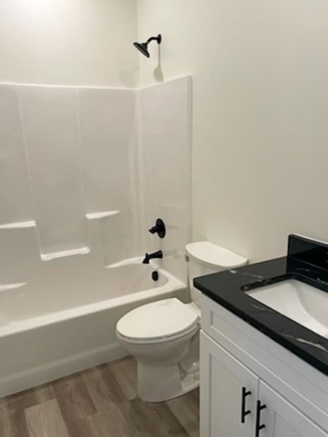 full bathroom with shower / washtub combination, toilet, hardwood / wood-style floors, and vanity