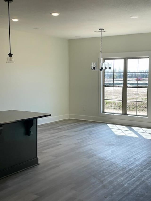 unfurnished dining area with dark hardwood / wood-style floors and a chandelier