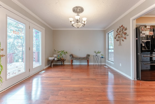 unfurnished room with hardwood / wood-style flooring, ornamental molding, and a chandelier