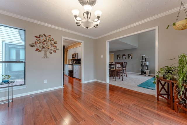 unfurnished room with crown molding, an inviting chandelier, and hardwood / wood-style flooring