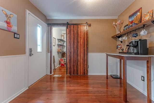 entrance foyer featuring hardwood / wood-style flooring, a barn door, and a textured ceiling