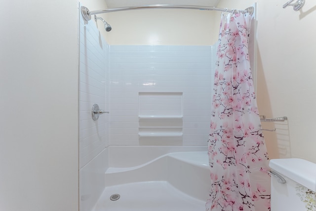 bathroom with a shower with curtain and toilet