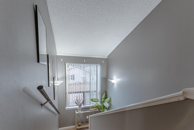 stairs featuring lofted ceiling and a textured ceiling