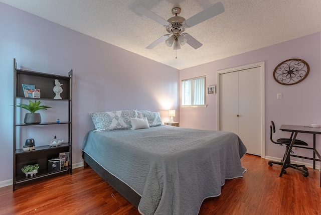 bedroom with wood-type flooring, a textured ceiling, and ceiling fan