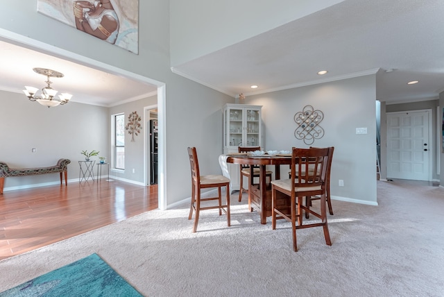 carpeted dining space featuring crown molding and a chandelier