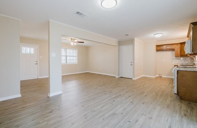 unfurnished living room with crown molding, ceiling fan, and light hardwood / wood-style floors