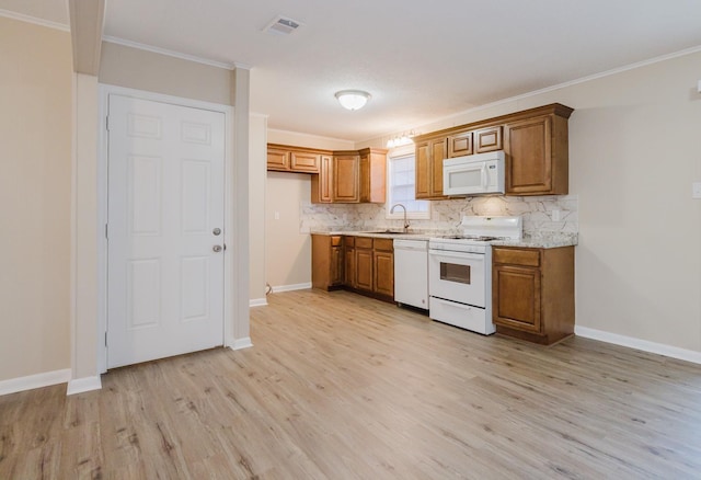 kitchen featuring crown molding, sink, backsplash, and white appliances