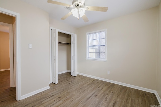 unfurnished bedroom with light hardwood / wood-style flooring, ceiling fan, and a closet