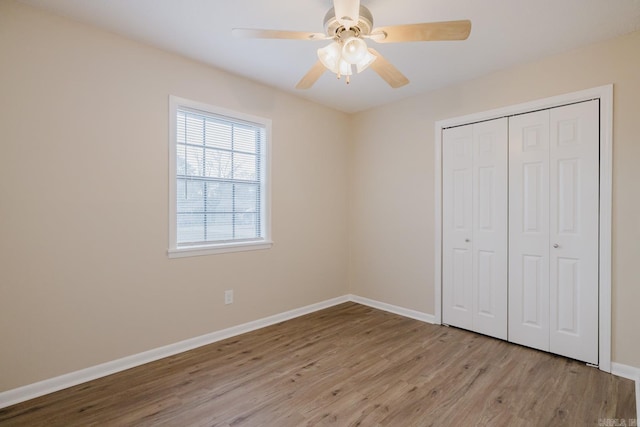 unfurnished bedroom featuring ceiling fan, a closet, and light hardwood / wood-style flooring