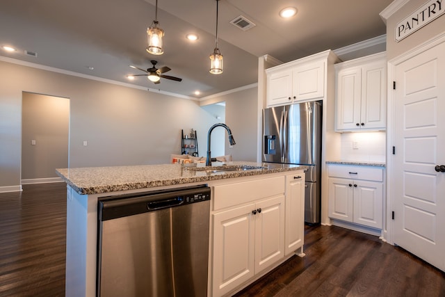 kitchen with appliances with stainless steel finishes, an island with sink, sink, white cabinets, and backsplash