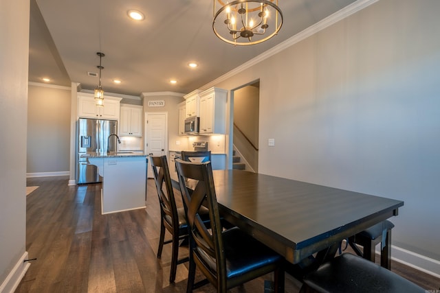 dining space with crown molding, dark hardwood / wood-style floors, sink, and a notable chandelier