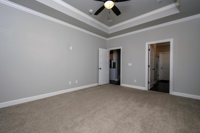 unfurnished bedroom with a raised ceiling, crown molding, carpet floors, and ceiling fan