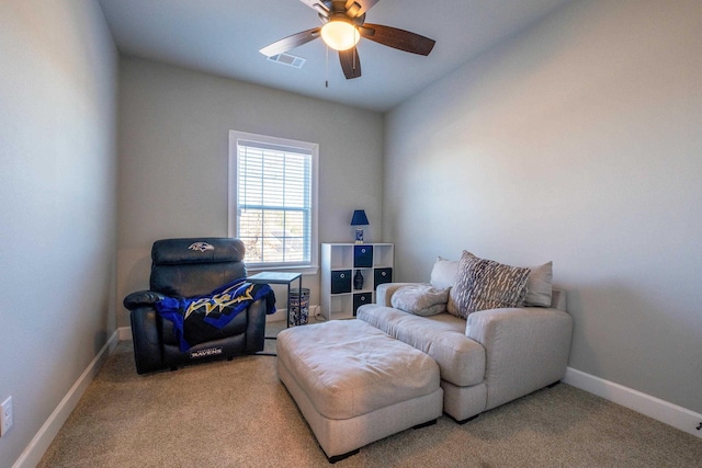 living area featuring light carpet and ceiling fan