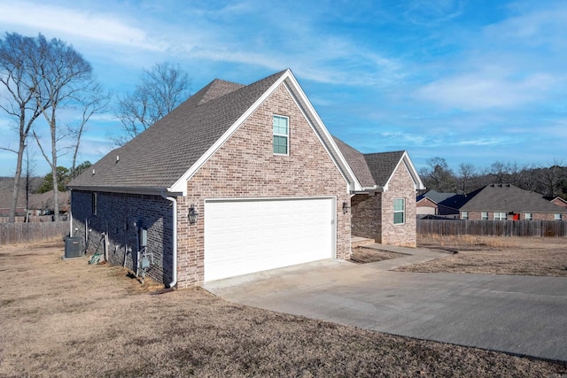 view of front of home with a garage and central air condition unit