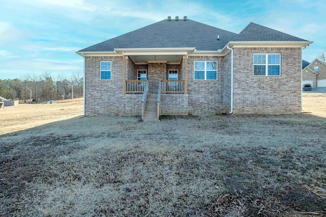 back of house featuring a porch and a lawn