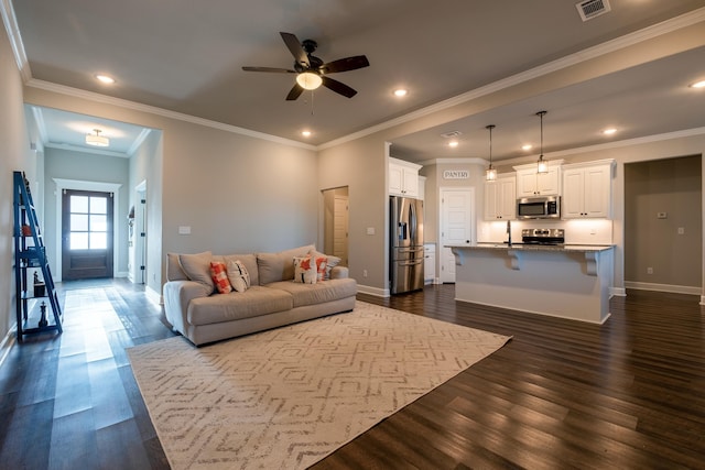 living room with dark hardwood / wood-style flooring, crown molding, and ceiling fan