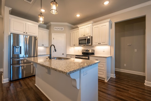 kitchen with appliances with stainless steel finishes, white cabinetry, sink, a kitchen island with sink, and light stone countertops