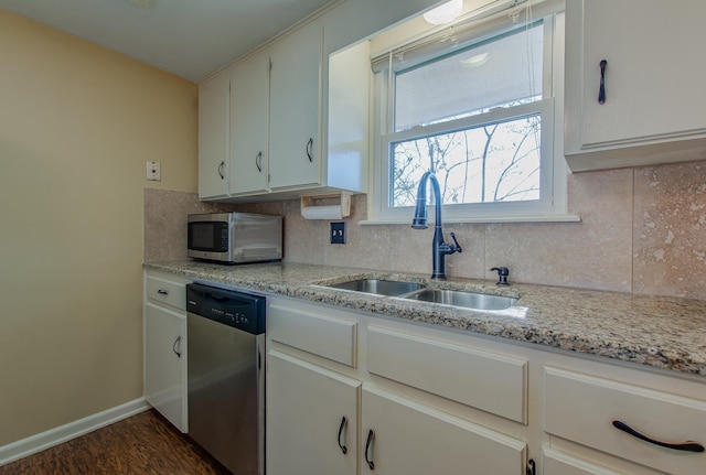 kitchen with sink, light stone counters, dark hardwood / wood-style floors, stainless steel appliances, and white cabinets