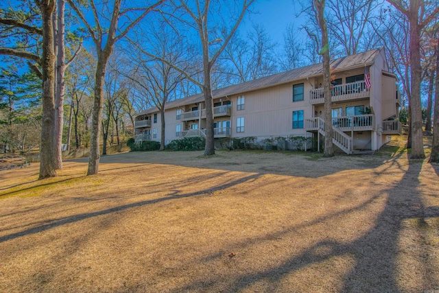 view of front of property featuring a front lawn and a balcony