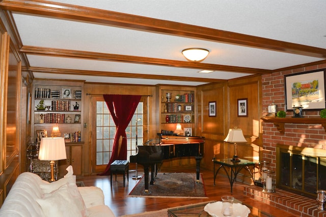 interior space featuring hardwood / wood-style floors, a fireplace, a textured ceiling, beamed ceiling, and wood walls