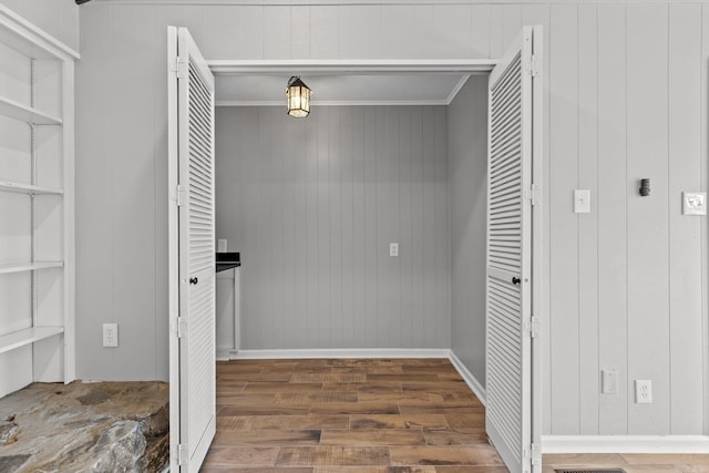 laundry room with ornamental molding, dark hardwood / wood-style floors, and built in features