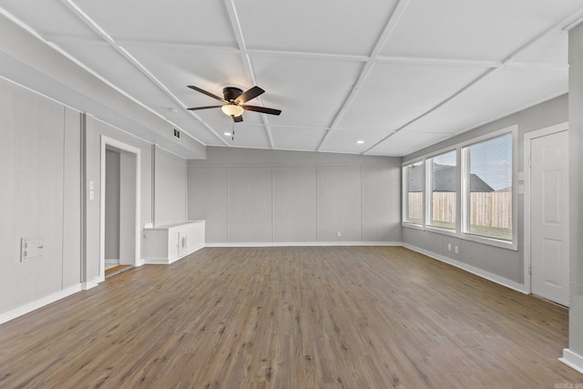 unfurnished living room with hardwood / wood-style flooring, ceiling fan, and coffered ceiling