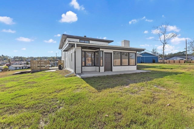 back of house with a yard, a patio, and a sunroom