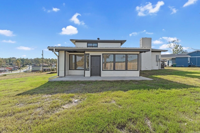 rear view of house featuring a yard and a patio area