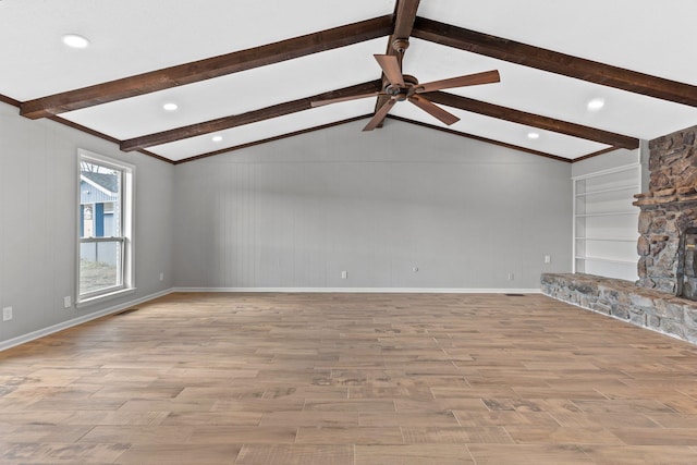 unfurnished living room featuring a fireplace, built in features, lofted ceiling with beams, and light wood-type flooring