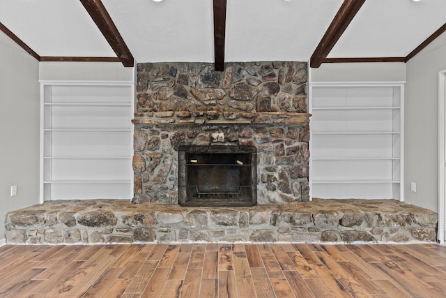 room details with built in features, wood-type flooring, a fireplace, and beam ceiling