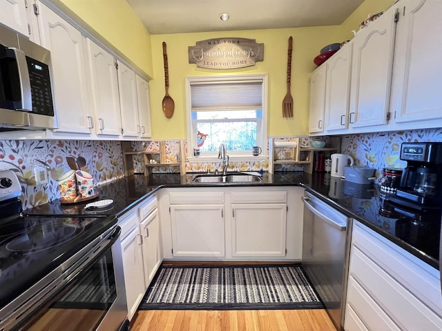 kitchen featuring tasteful backsplash, sink, stainless steel appliances, and white cabinets