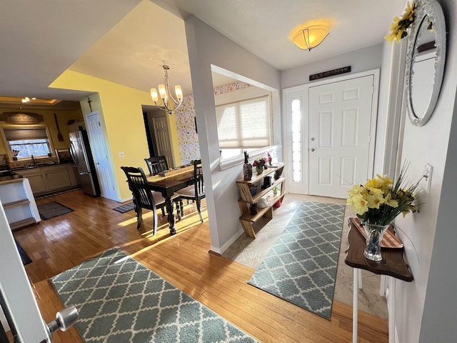 entryway featuring hardwood / wood-style floors, sink, and a chandelier