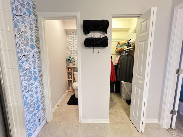 interior space featuring toilet and tile patterned flooring